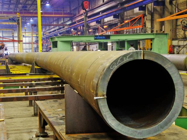 A Long Section Of Heavy, Thick Walled Pipeline With A 30" Diameter Undergoes Custom Bending In A Workshop
