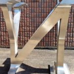 A Shiny Stainless Steel Sculpture Of A Central Letter "N" Which Changes Into The Letter "Y" At Each Side
