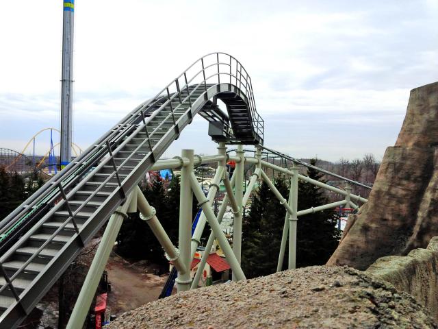 Canada's Wonderland's "The Guardian" Roller Coaster Track With Maintenance Stairs And Platform Ascends To It's Crest With Other Rides In The Background.