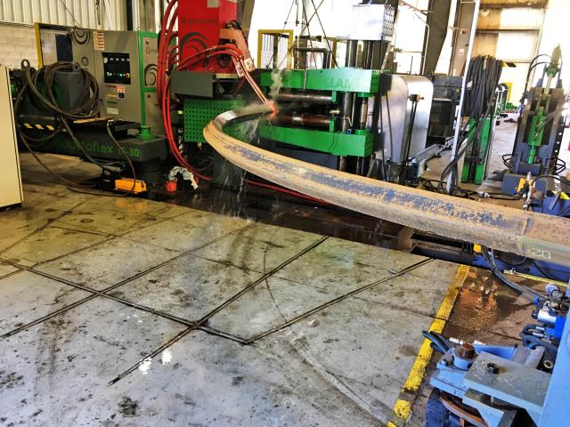 A Long, Square Section Undergoes Custom 2D Forming Via Induction Bending In A Workshop