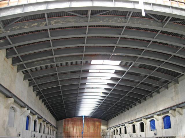 A Building Under Construction Showing The Curved Roof Structural Steel Beams
