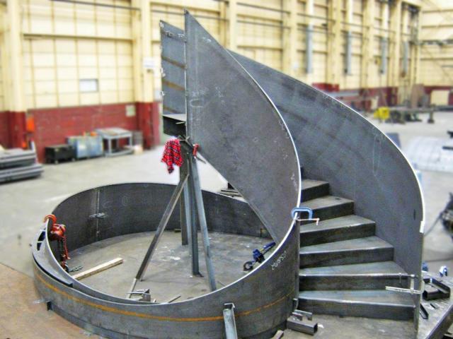 A Custom Curved Staircase Stringer And Set Of Runners Being Fabricated In A Workshop