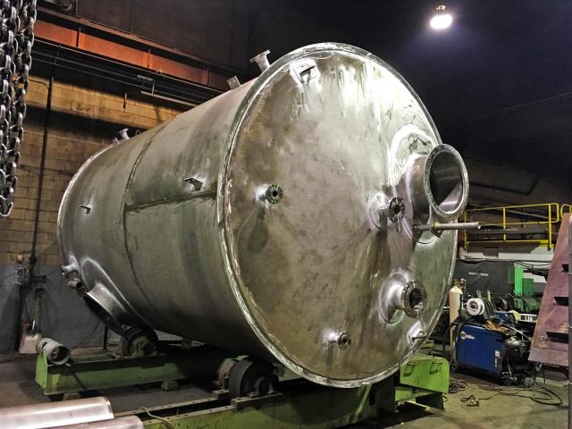A Large Horizontal Cylindrical Vessel For Bisulfate Storage With Flange Attachments Under Construction In A Workshop