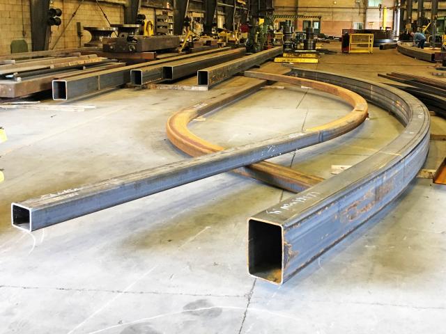 Lengths Of Rolled Hollow Structural Sections Of Different Shapes And Profiles Sit In A Workshop