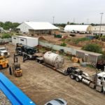 An Aerial View Of Two Cylindrical Vessels For Bisulfate Storage With Flange Attachments Are Loaded Onto Trucks In A Yard