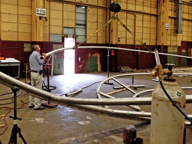 The Sculptor Positions Rolled Stainless Steel Pipe Sections In A Circular Arrangement In A Workshop For The Sculpture "Wisdom"