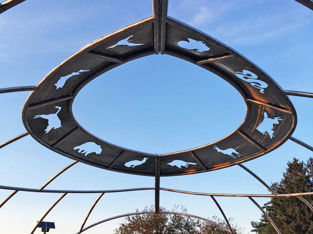 The Sculpture "Wisdom" By Gordon Reeve At Sunset, Fabricated From A Mesh Of Custom Rolled Stainless Steel Pipe Which Resembles A Circular Playground Climbing Structure