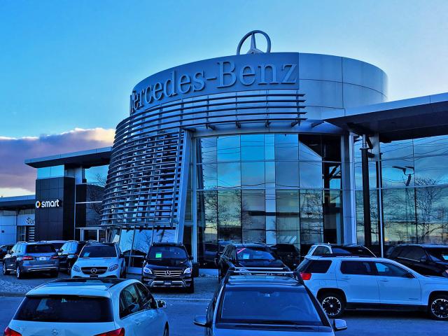 A Car Dealership With A Facade Of Curved Aluminum Sections Made Into A Frame