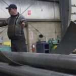 Un trabajador revisa un larguero de escalera fabricado a medida durante el laminado de placas en Kubes Steel