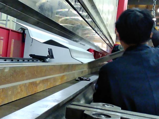 Sections Of Steel Plate Are Custom Fabricated Into Corrugated Pieces Via Press Brake In A Workshop