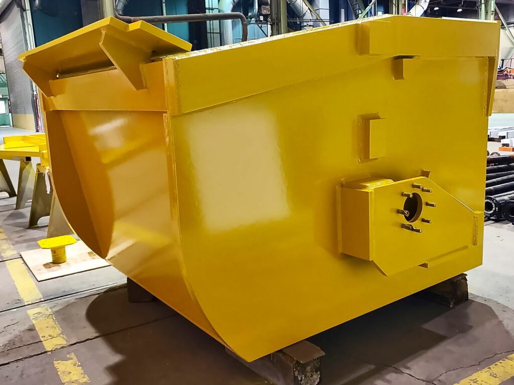 A Custom Fabricated Scrap Handling Bucket Sits In A Workshop