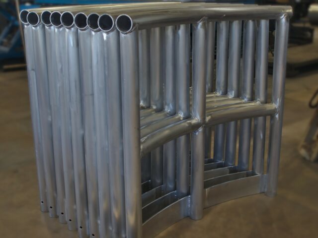 Finished Sections Of Custom Fabricated Curved Aluminum Hand And Guard Rails Sit Together