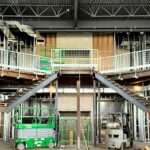 Custom Spiral Staircases Under Construction Ascend From The Sides Of A Lobby To A Central Landing.