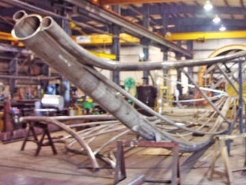 La sculpture d'art public "Rafaga Unleashed" en construction pour une installation au Pier 8 Waterfront Park à Hamilton, Ontario, Canada, avec des sections en acier inoxydable laminées et fabriquées sur mesure pour la partie "voile" par Kubes Steel