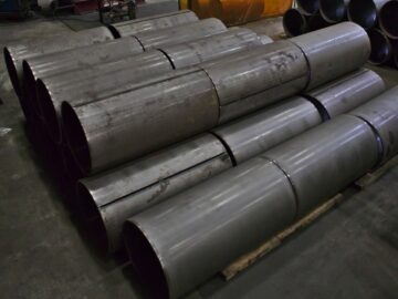 Pilas de cilindros de acero fabricados a medida en construcción en Kubes Steel