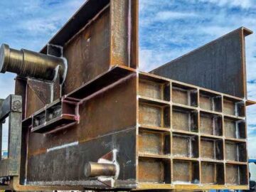 A Calibrated Bucket Scale For Industrial Use Is Being Loaded Onto A Truck By Two Forklifts